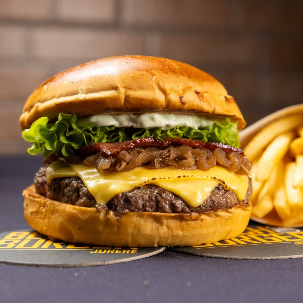 Burger Noronha com cebola marinada, bacon, queijo prato e alface, ao lado das fritas